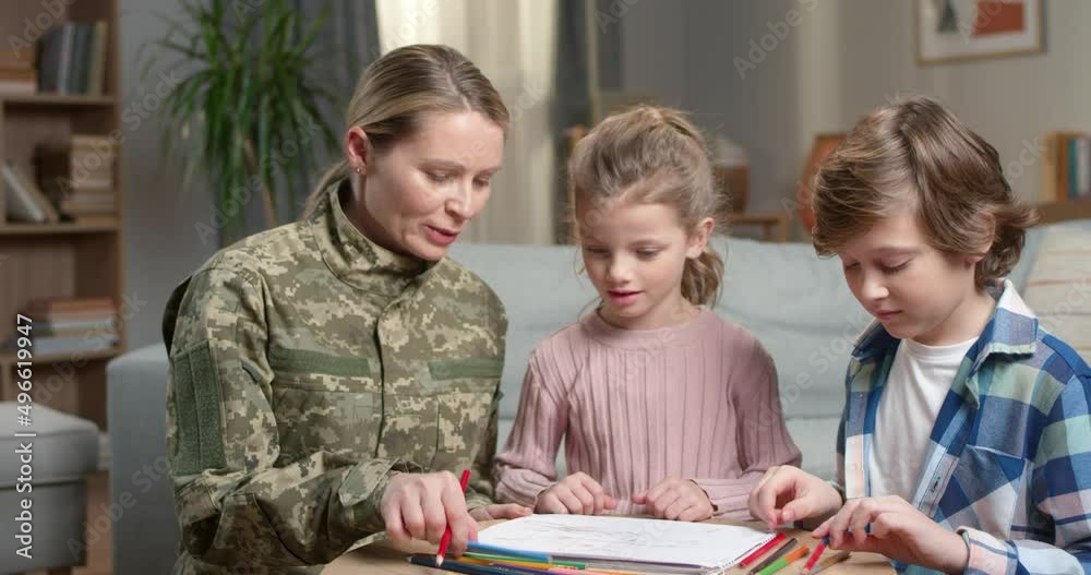 Woman in army uniform drawing with son and daughter Woman in army uniform drawing with son and daughter