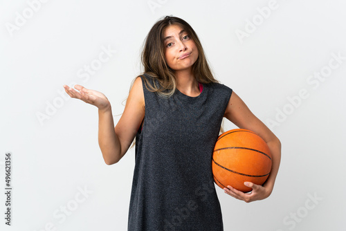Young woman playing basketball isolated on white background having doubts while raising hands © luismolinero