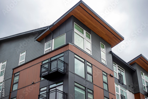 Low angle view of a modern style business building, with lots of windows on a sunny, cloudy day