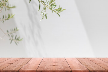 Empty wood table top and blurred white wall in garden background with Green leaves - can used for display or montage your products.