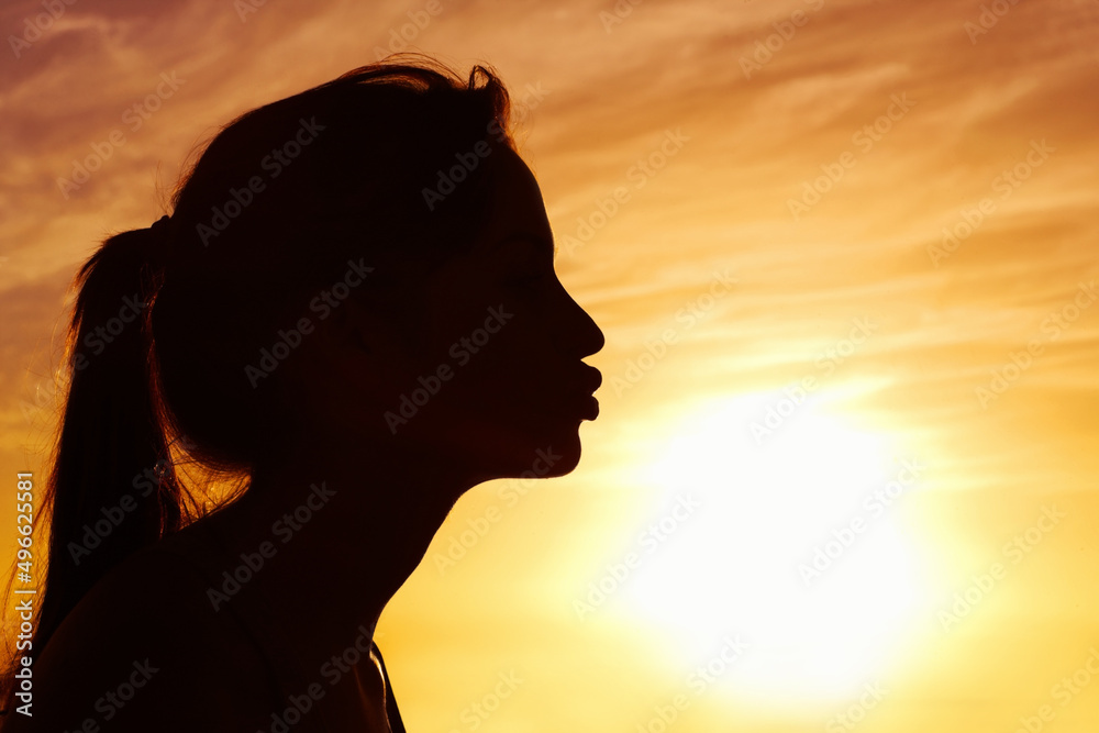 Closeup of a woman kissing the sun against beautiful sky. Profile view of a woman kissing the sun against beautiful sky. Closeup of a woman kissing the sun against beautiful sky. Profile view of a woman kissing the sun against beautiful sky.