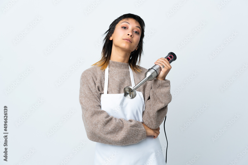Chef Uruguayan girl using hand blender over isolated white background keeping arms crossed Chef Uruguayan girl using hand blender over isolated white background keeping arms crossed