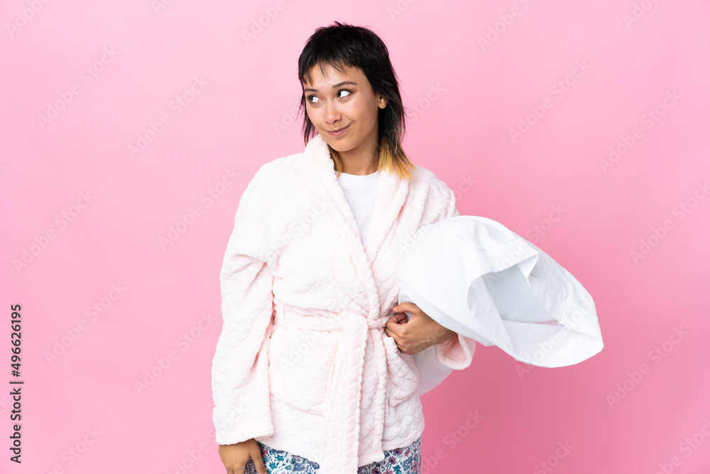 Young Uruguayan woman in pajamas over isolated pink background standing and looking to the side Young Uruguayan woman in pajamas over isolated pink background standing and looking to the side