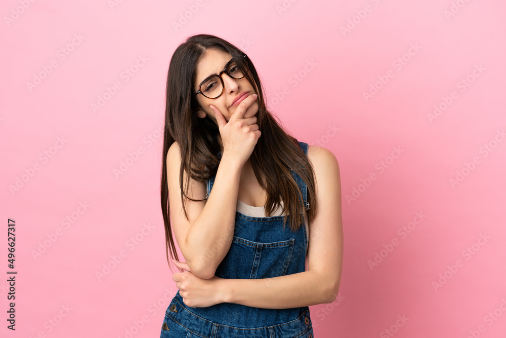 Young caucasian woman isolated on pink background having doubts Young caucasian woman isolated on pink background having doubts