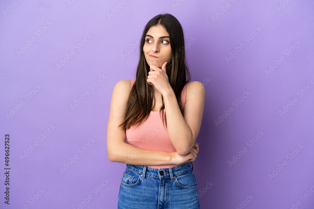 Young caucasian woman isolated on purple background having doubts and thinking Young caucasian woman isolated on purple background having doubts and thinking