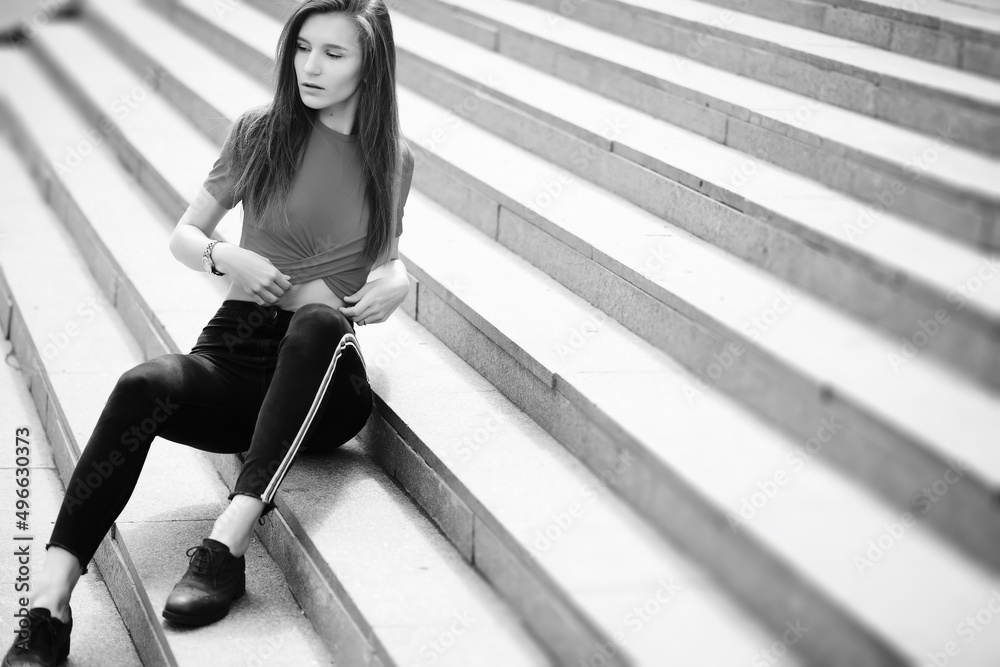Obraz premium A girl posing on the steps of a building
