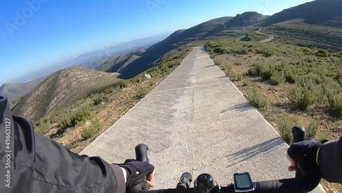 Bike ride along asphalt road outdoors in nature parkland on sunny day, first person view 	