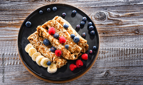 A plate of pancakes with cheese and fruits photo