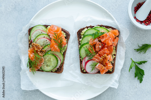 Smorrebrod. Danish toasts with dark rye bread, salmon avocado. top view photo