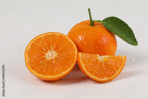 Fototapeta Naklejka Na Ścianę i Meble -  oranges, halved oranges, healthy fruit, mandarin oranges, vitamin C, against white background with refreshing water droplets