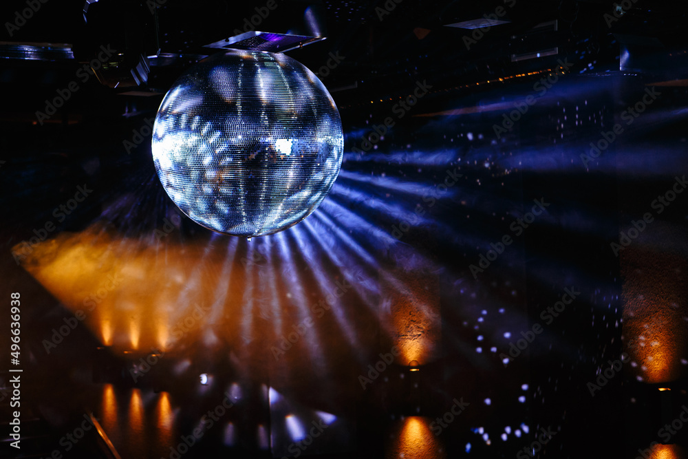 Disco ball hanging on the ceiling of the disco Rays of light are reflected from it