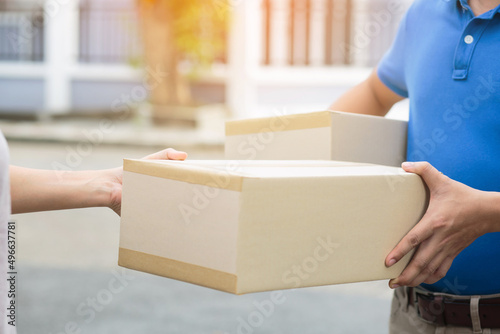 parcel delivery man wear protective gloves blue and mask, protect Hygiene germ and bacteria of a package through a service send to home. hand holding consign and submission customer accepting a of box © methaphum