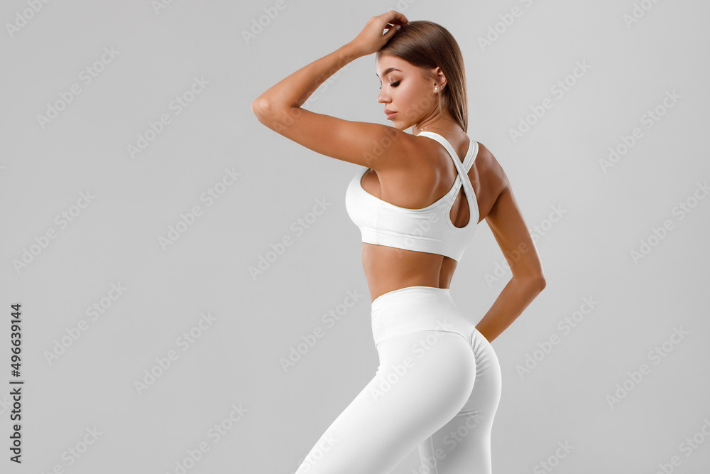 Sexy fitness woman. Beautiful athletic girl, isolated on the gray background - obrazy, fototapety, plakaty 