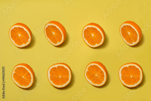 Orange with halves ripe orange on yellow background