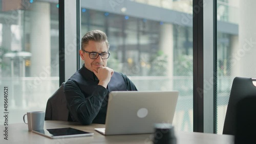 Businessman using laptop computer in office. Happy middle aged man, entrepreneur, small business owner working online.