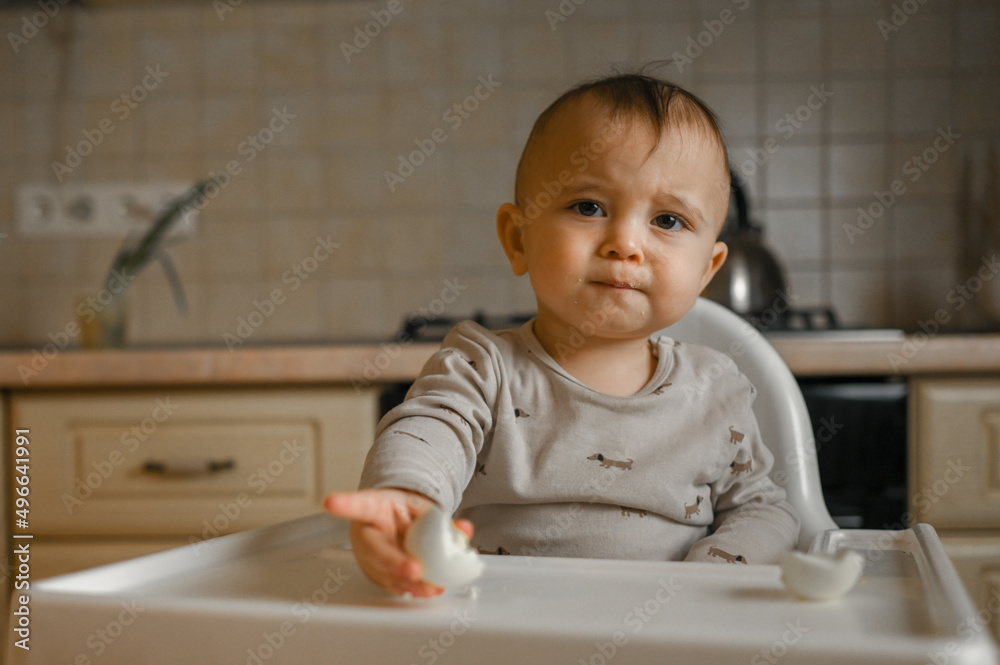 the kid is at home in the kitchen eating an egg the kid is at home in the kitchen eating an egg