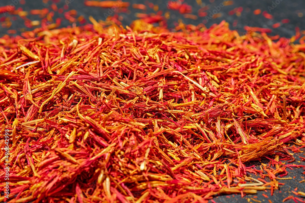 Naklejka premium Saffron threads on dark background, close up, selective focus. Aromatic spices and seasonings
