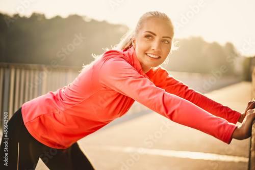 Active young woman stretching after morning running exercise