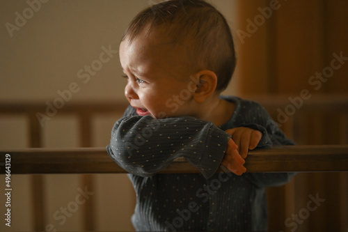 a six-month-old baby is crying in a crib