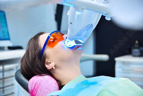 Teeth whitening for patient in protective glasses. photo