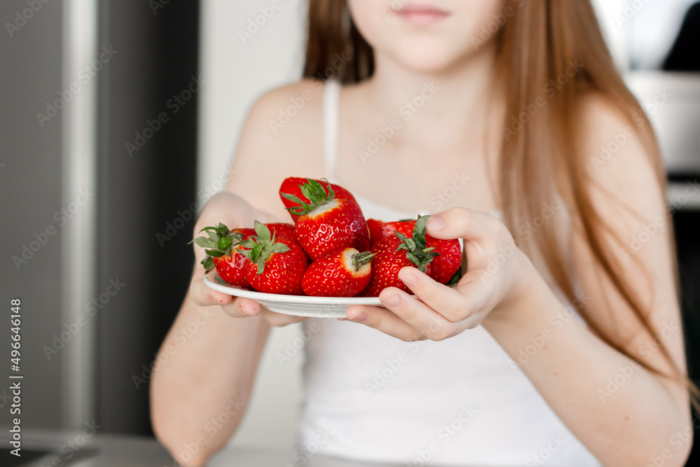 Preteen girl holding raw straberry, eating healthy food, drinking milk Preteen girl holding raw straberry, eating healthy food, drinking milk