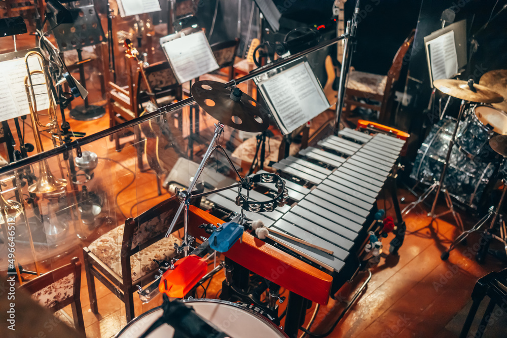 Musical instruments in the orchestra pit of the theater. Professional  xylophone. A percussion cymbal. Drum kit. Notebooks with sheet music, music  stand. Stock Photo | Adobe Stock