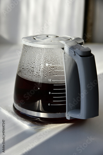 Glass coffee jug with a drink on a white background
