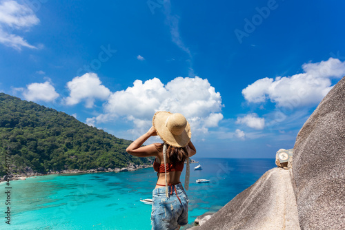 back view of women wearing a straw hat standing in view Beautiful sea and blue sky at Similan island, Phuket,Thailand. © suriya