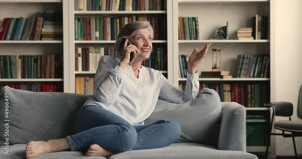 Middle-aged woman spend leisure alone at home relaxing on cozy couch holds smartphone enjoy pleasant personal conversation, having remote communication. Older gen use modern tech, make call concept Middle-aged woman spend leisure alone at home relaxing on cozy couch holds smartphone enjoy pleasant personal conversation, having remote communication. Older gen use modern tech, make call concept