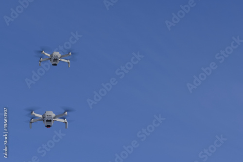 Two modern Remote Control Air Drones Fly with action cameras in blue sky. Modern technologies. Close up. Travel, hobby, inspiration. © Robert