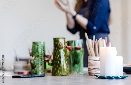 A burning candle stands on the table creating a cozy atmosphere in a pottery trowel