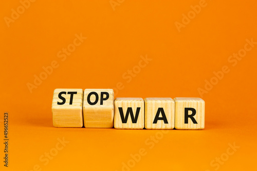 Stop war symbol. Turned cubes and changed concept words War to Stop war. Beautiful orange table orange background. Business and stop war concept. Copy space.