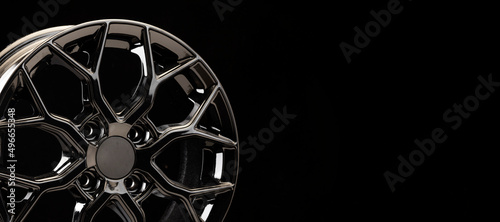 black tuning sports alloy wheel fragment detail on a black background copyspace copy space panorama