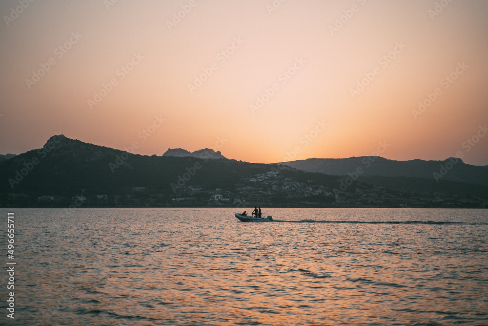 Unknown people in the boat on the sunset