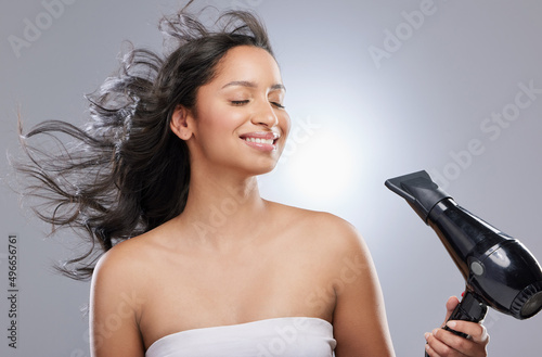 The upsides to being a brunette are clear. Studio shot of a beautiful young woman blowdrying her hair.