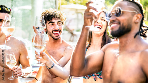Trendy friends drinking white wine champagne at swimming pool party - Vacation life style concept with young guys and girls having fun together on summer day at luxury resort - Warm bright filter © Mirko Vitali