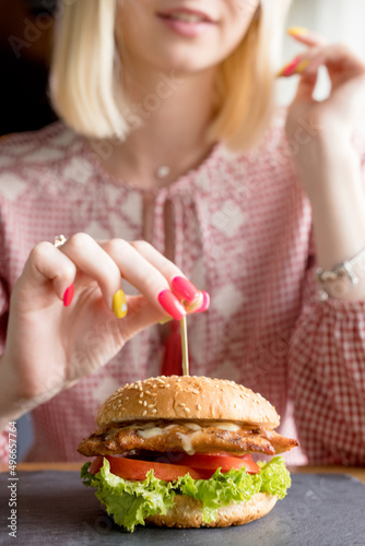 girl takes appetizing tasty burger, fast food concept