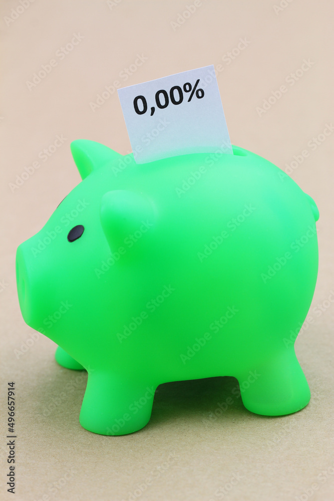 Piggy bank with interest rate 0,00% written on white paper