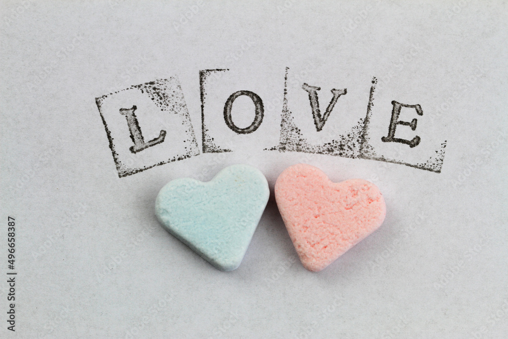 Word love made with letter stamps and big red heart on white background