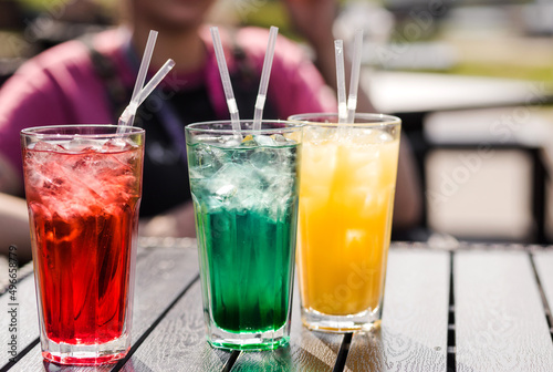 Multi-colored cocktails stand on a table on the street terrace of a cafe