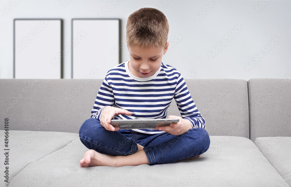 The child holds a gadget in his hands. The child holds a gadget in his hands.