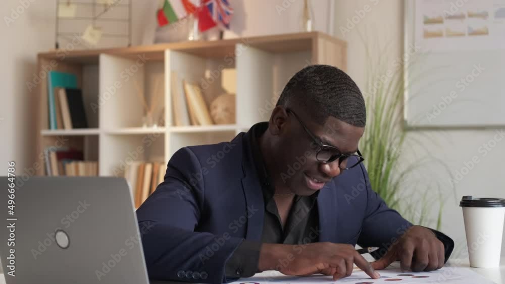 Business income. Data management. Marketing analytics. Cheerful man accountant checking statistics graphs satisfied with sale progress at office workplace. Business income. Data management. Marketing analytics. Cheerful man accountant checking statistics graphs satisfied with sale progress at office workplace.