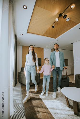 Young family arrive into hotel room