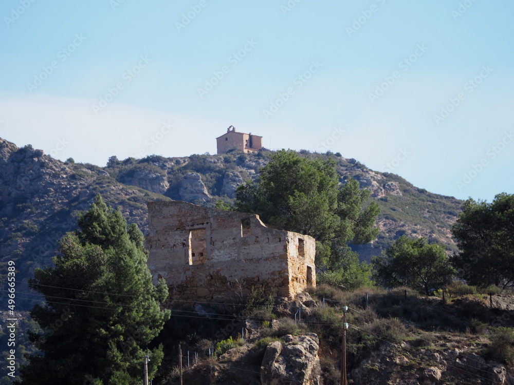 Fototapeta premium antigua ermita de sant jordi en la sierra de la carbonera, pirineos de lérida, en primer plano se encuentran los restos del castillo del pueblo de camarasa, españa, europa
