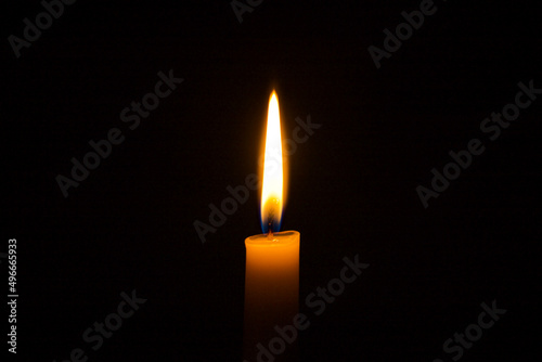 candle burns on a black background. flame of a wax candle in the dark.