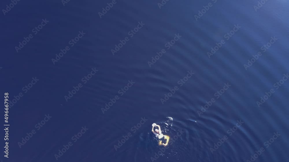 Woman swimming in a clear blue lake on a hot summers day. Birds eye view. Woman swimming in a clear blue lake on a hot summers day. Birds eye view.