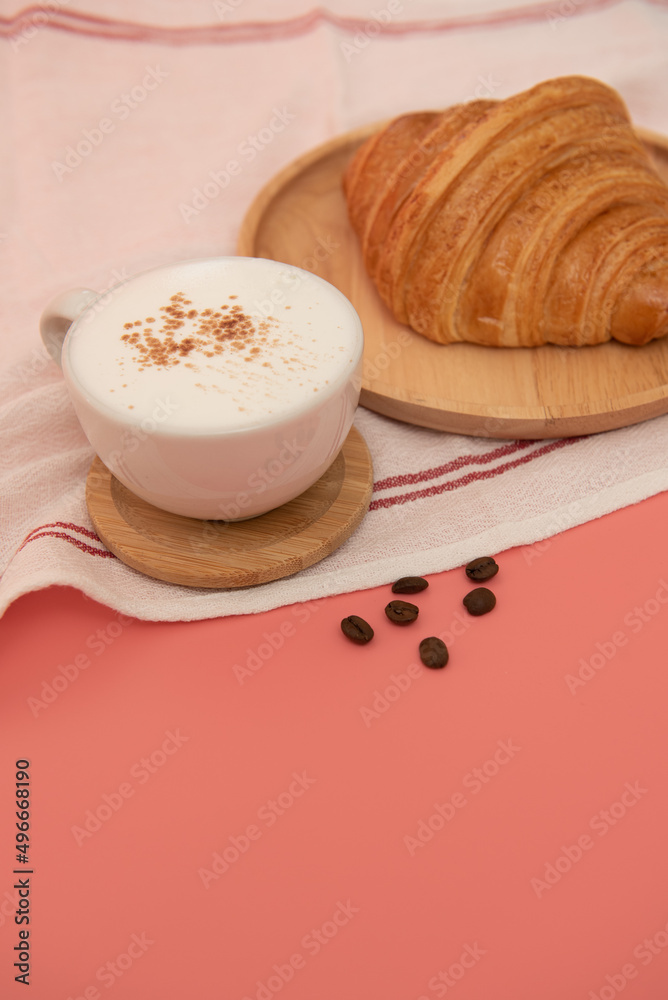 Coffee cup and fresh baked croissants on wooden background on the table Coffee cup and fresh baked croissants on wooden background on the table