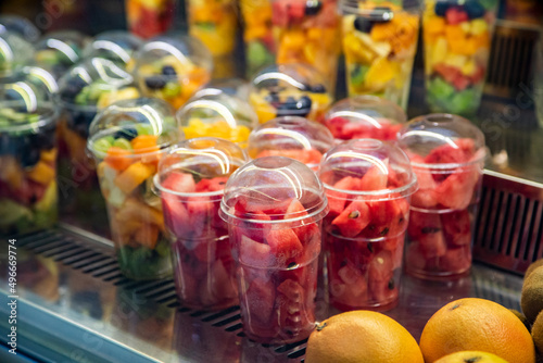 Obraz na płótnie fruit slicing in a cup. Exhibition of a plastic box with fresh cut pieces of fruit in the store. Convenience, healthy w salonie
