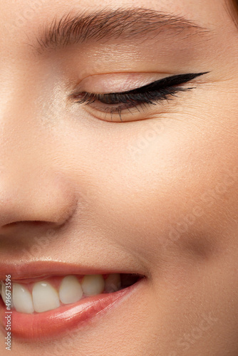 Close-up of woman's lips with fashion natural beige lipstick makeup. Macro sexy pale lipgloss make-up . Gentle pure skin and wavy blonde hair. Cosmetology, Spa, increase in lips