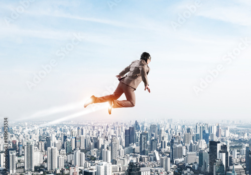 Photographie Businessman in suit and aviator hat flying in sky